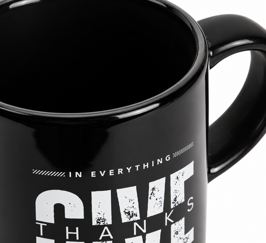 Close-up of Give Thanks mug showing its glossy black ceramic finish and white printed design