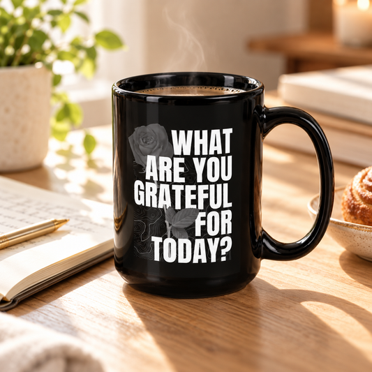 Black What Are You Grateful For Today mug on a sunlit kitchen counter with a croissant